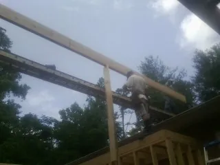Carpenter setting a ridge beam over a new addition frame — Ice Dam Removal by Roofing Brothers in Troutville