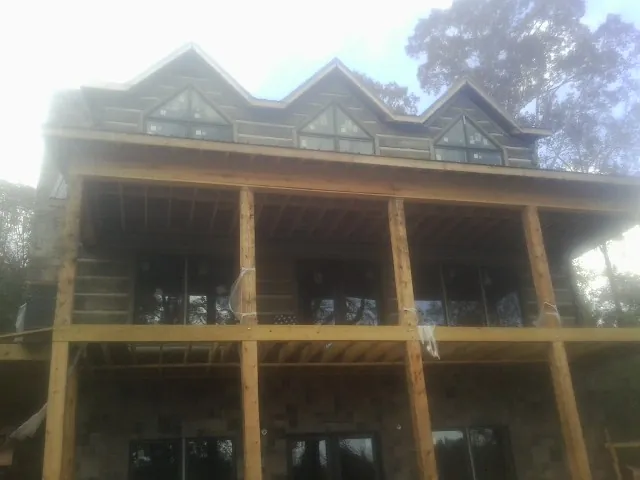 Dormers and porch framing on a large log home under construction — Roof Coating work by our crew in Troutville